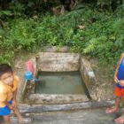 Kinder vor einem offenen Wasserkanal
