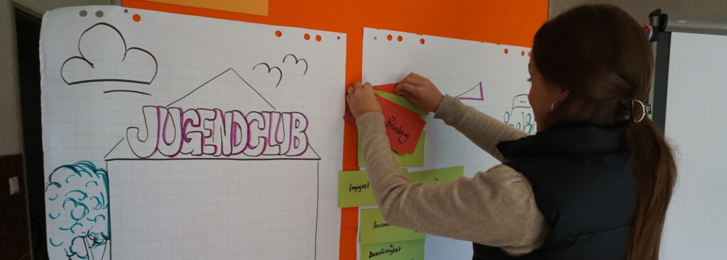 mädchen pinnt moderationskarten an